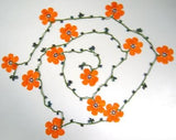 10.20.22 ORANGE OYA Flower Lariat Necklace with purplish black beads.